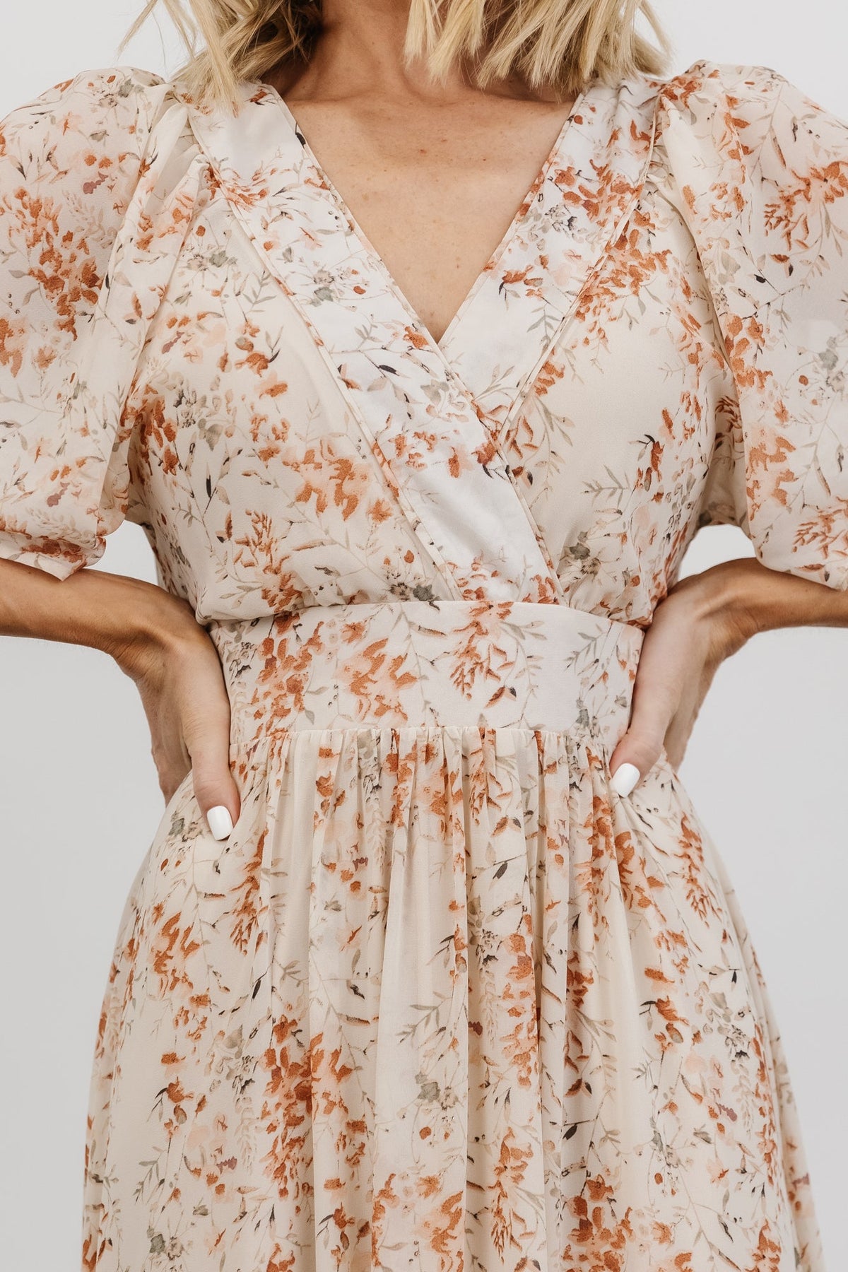 Full-length image of cream and rust floral maxi dress on model, showing natural drape and movement of the chiffon fabric.
