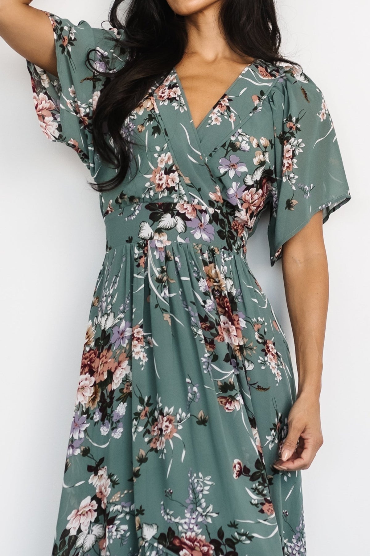 Close-up of surplice V-neckline and flutter sleeve detail on the Katherine Maxi Dress in dusty green floral, highlighting feminine finishing.
