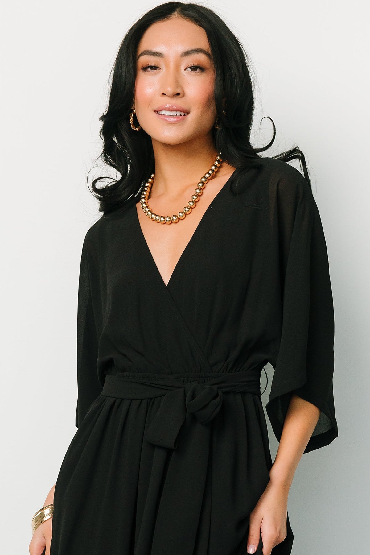 Three-quarter angle of Kia Kimono Maxi Dress in black highlighting loose kimono sleeves, detached self-tie sash and natural drape of the skirt.