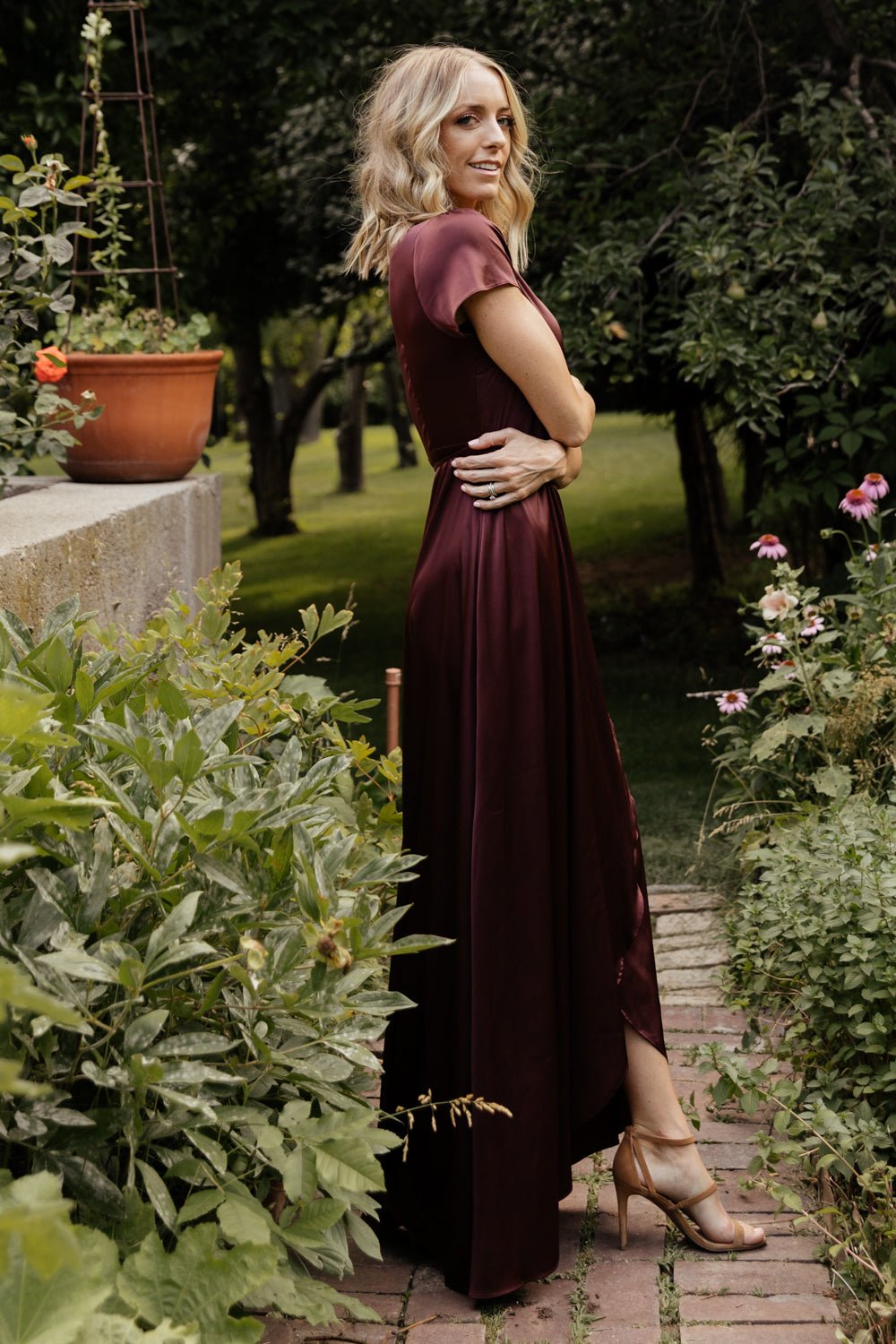 Close-up of waist detail on Krystal Satin Wrap Gown showing tied wrap, fabric texture and subtle shine of the dark clove satin.