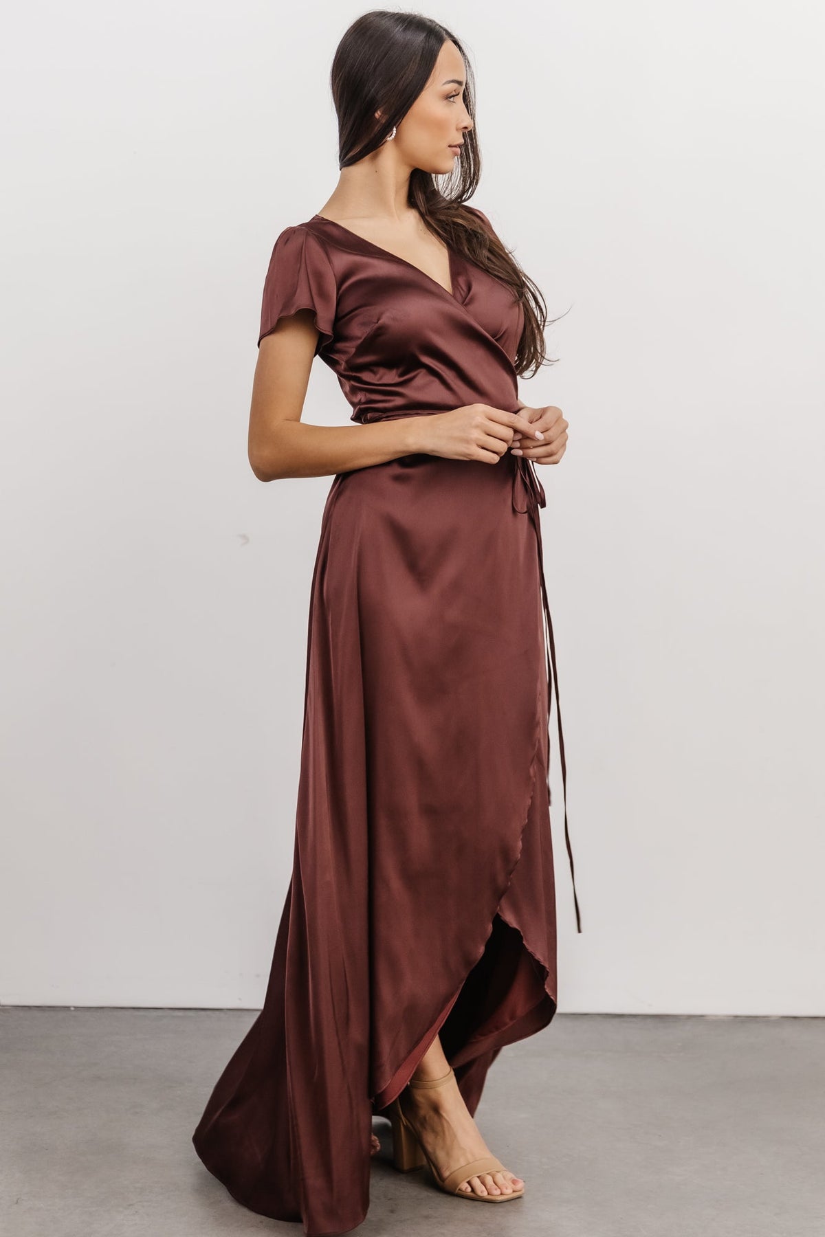 Full-length view of Krystal Satin Wrap Gown in dark clove showcasing maxi length, tulip skirt silhouette and polished satin finish.