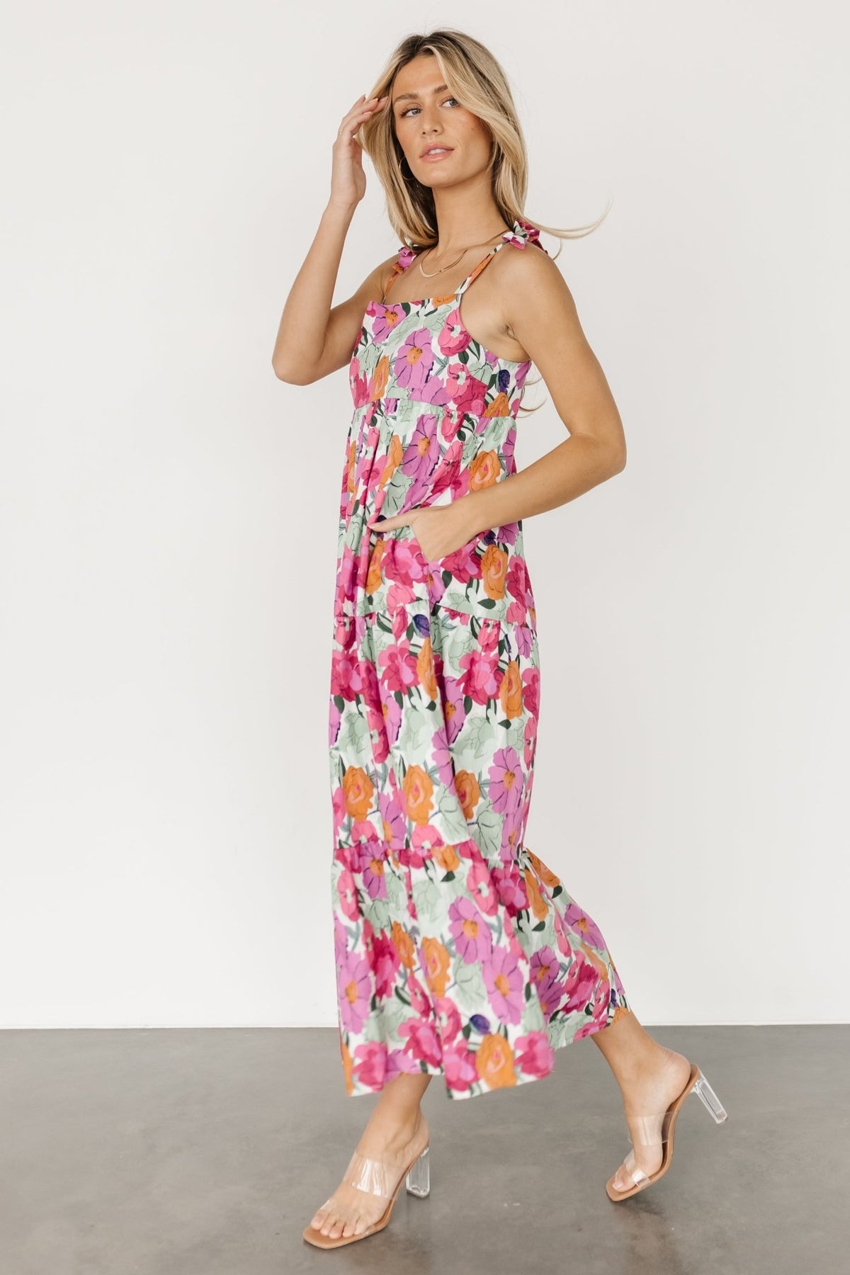 Side view showing a hidden side-seam pocket and the tiered silhouette of the Lakewood Tie Dress in floral print.