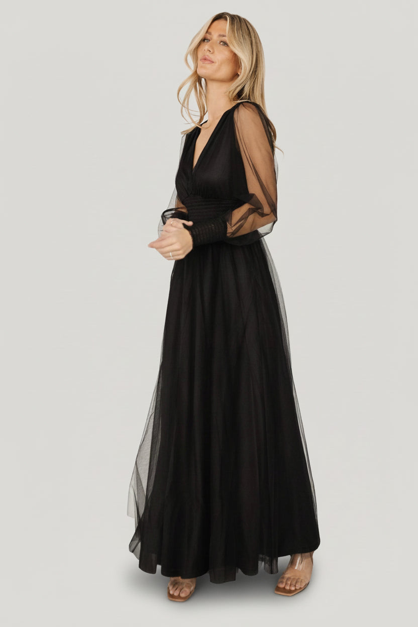 Back view of the black Layla Tulle Maxi Dress showing the flowing layered skirt, raw hem detail, and overall airy silhouette from behind.
