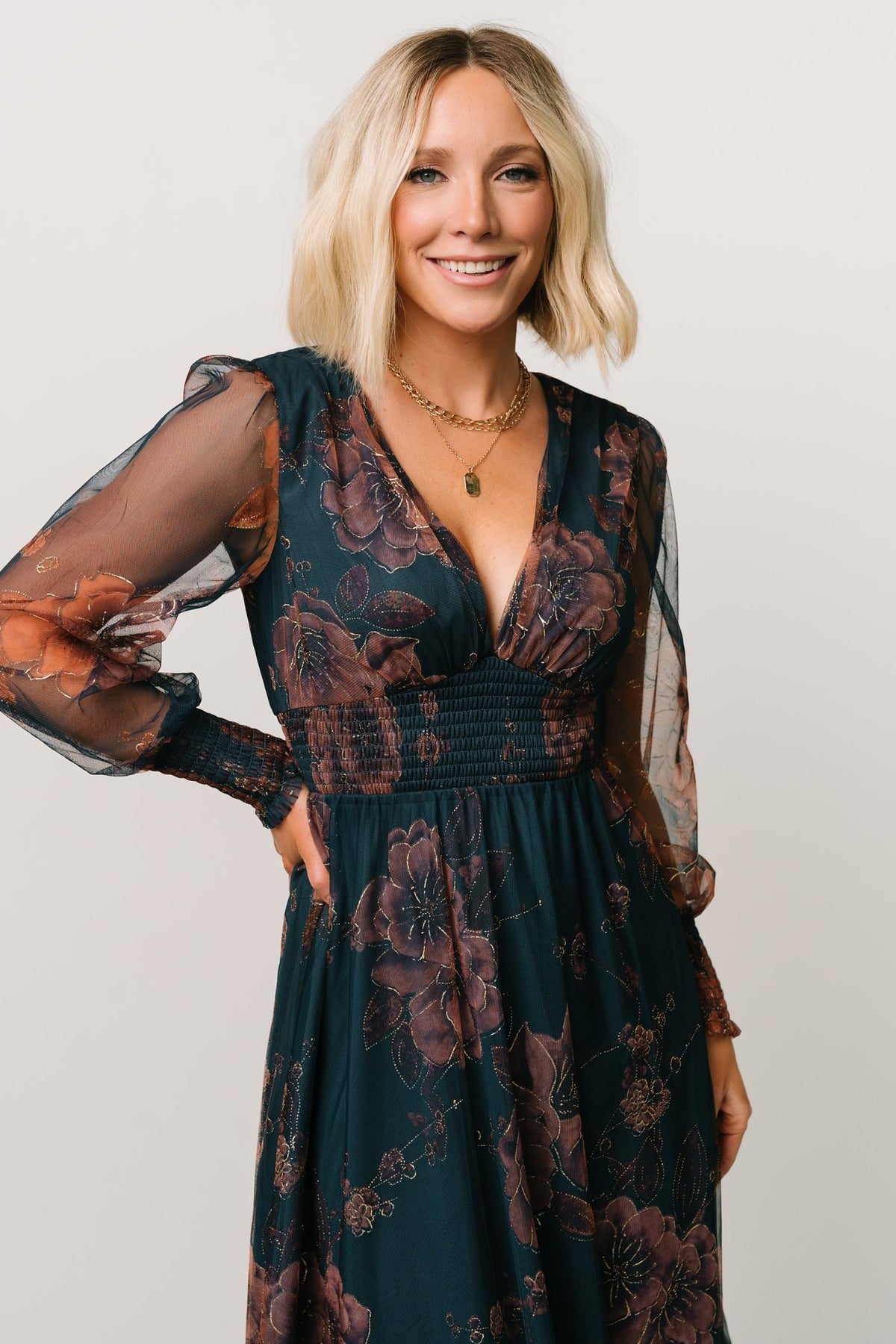 Three-quarter view of copper and blue metallic tulle maxi dress, showing sleeve detail, smocked cuffs, and layered tulle skirt movement on model.