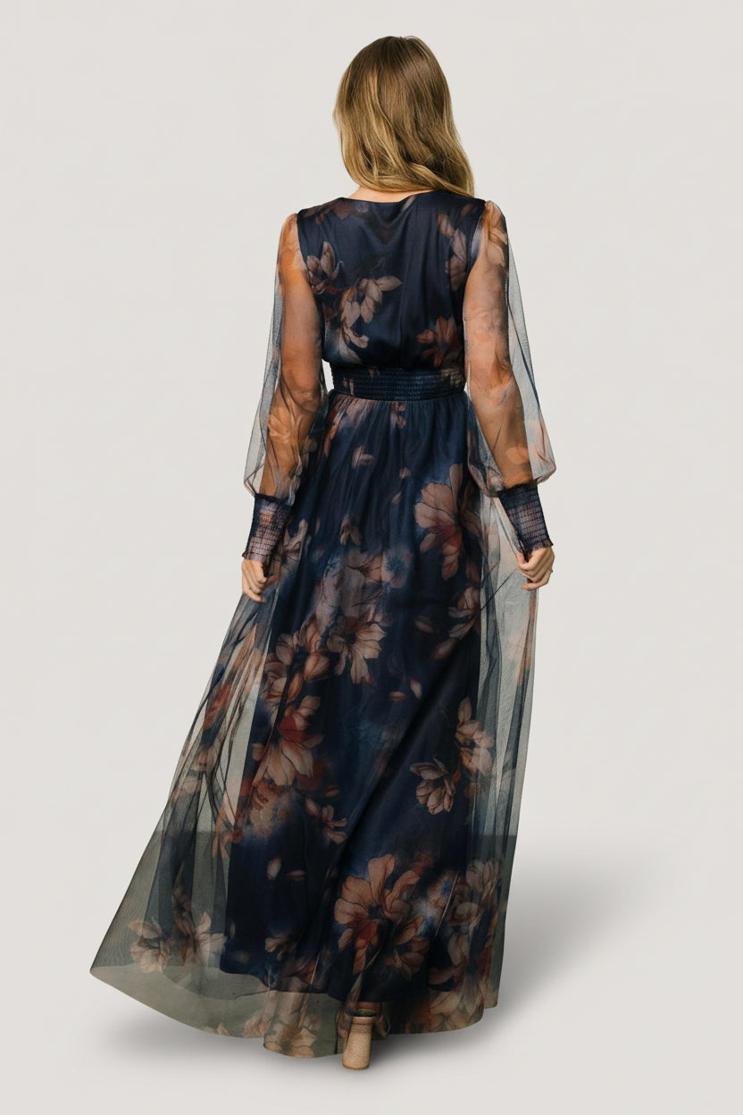 Full outfit shot of dark blue floral tulle maxi dress on model, showing length, silhouette, and smocked waist detail.