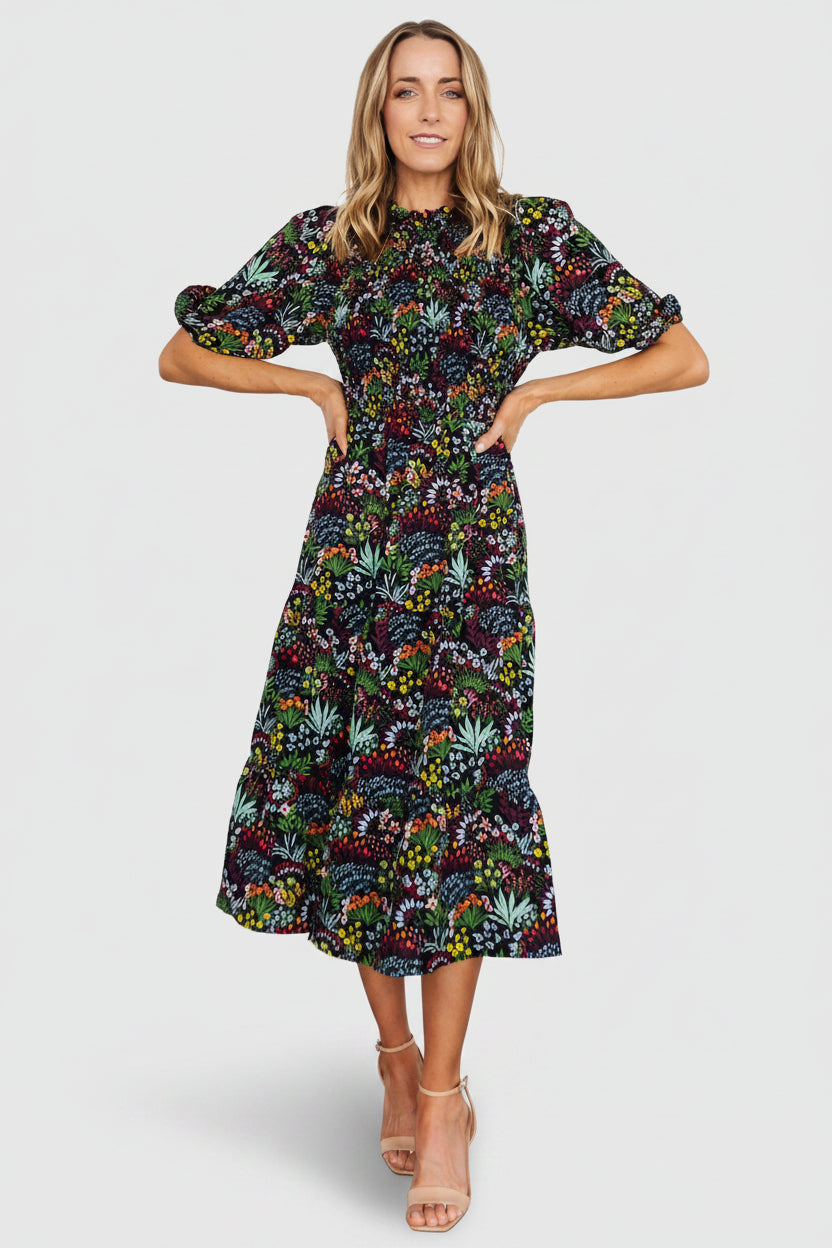 Front view of Lena Tiered Midi Dress in black multi floral, showing smocked bodice, ruffle high neckline and tiered chiffon skirt for movement.