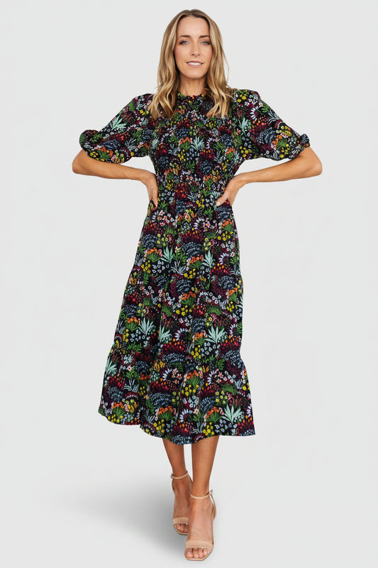 Front view of Lena Tiered Midi Dress in black multi floral, showing smocked bodice, ruffle high neckline and tiered chiffon skirt for movement.