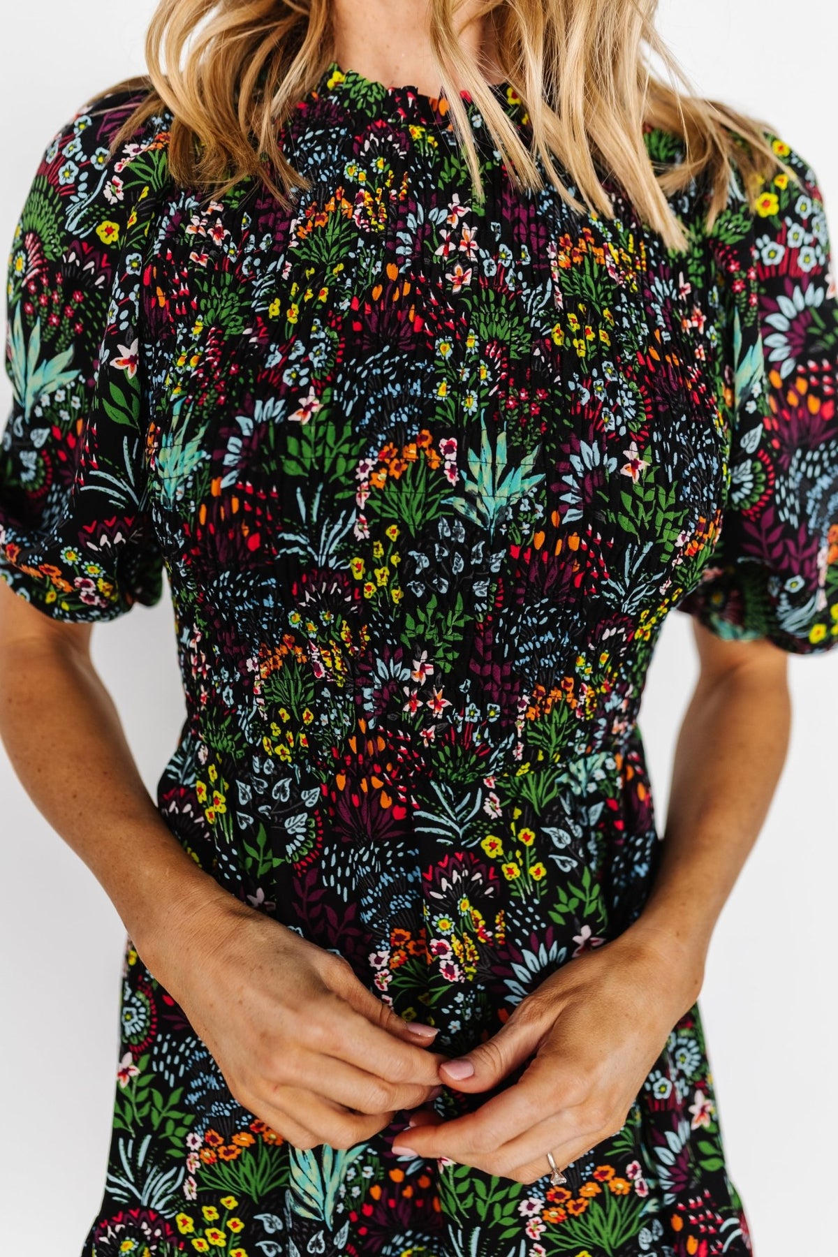 Model wearing Lena Tiered Midi Dress in black multi floral, side view highlighting mid-length sleeves with elastic cuffs and the tiered skirt silhouette.