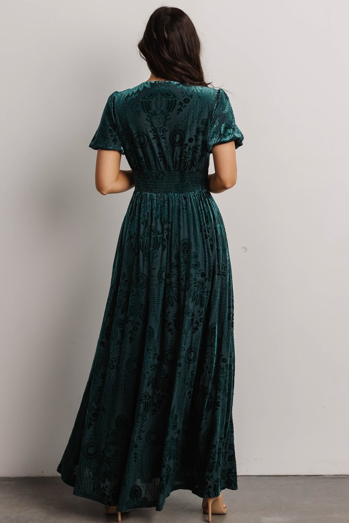 Close-up of short puff sleeve and V-neck seam on the embossed velvet dress, showing fabric finish and sleeve volume.