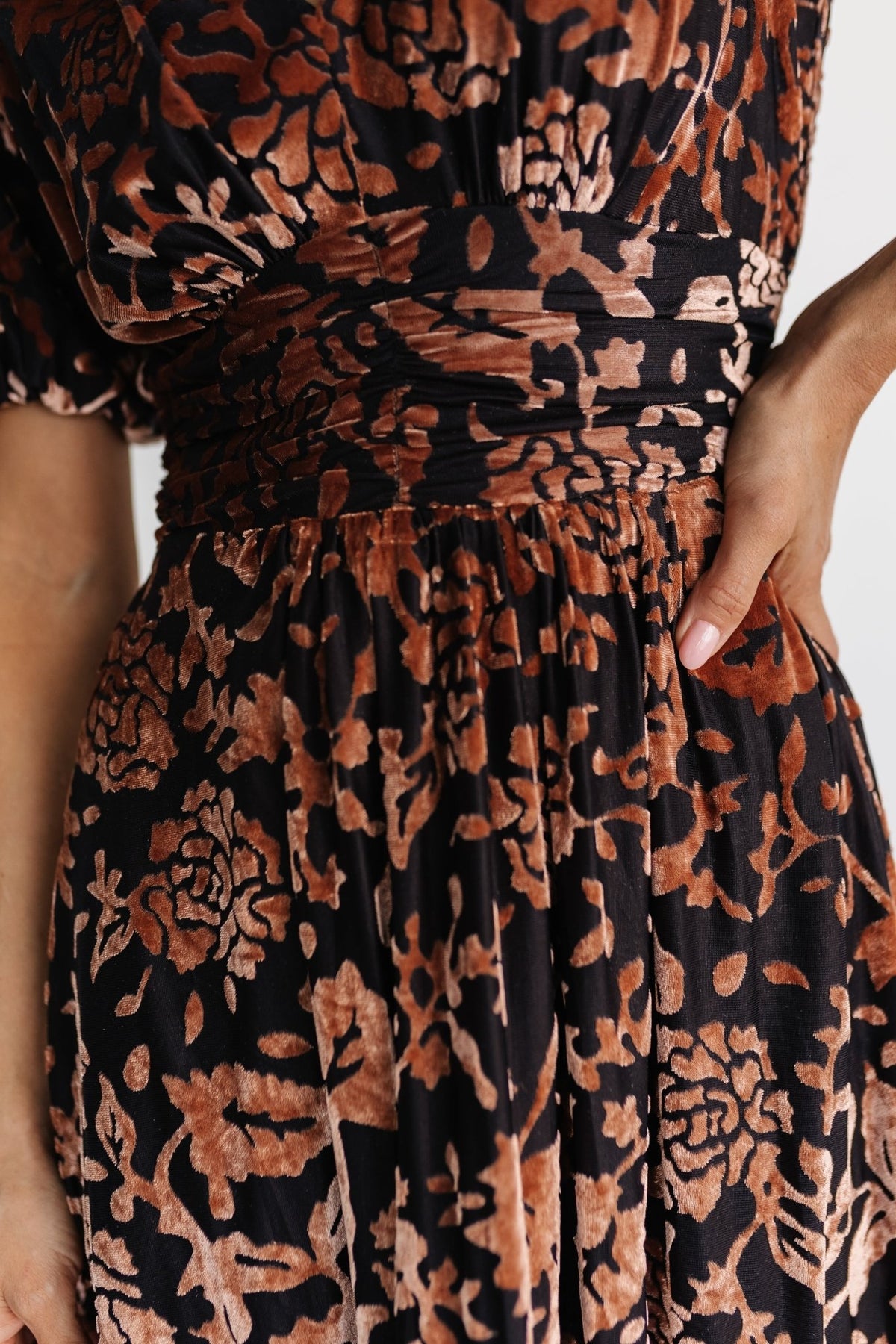 Close-up of embossed velvet fabric and waist gathering on the Leslie maxi dress, highlighting print detail and texture in Black + Bronze.