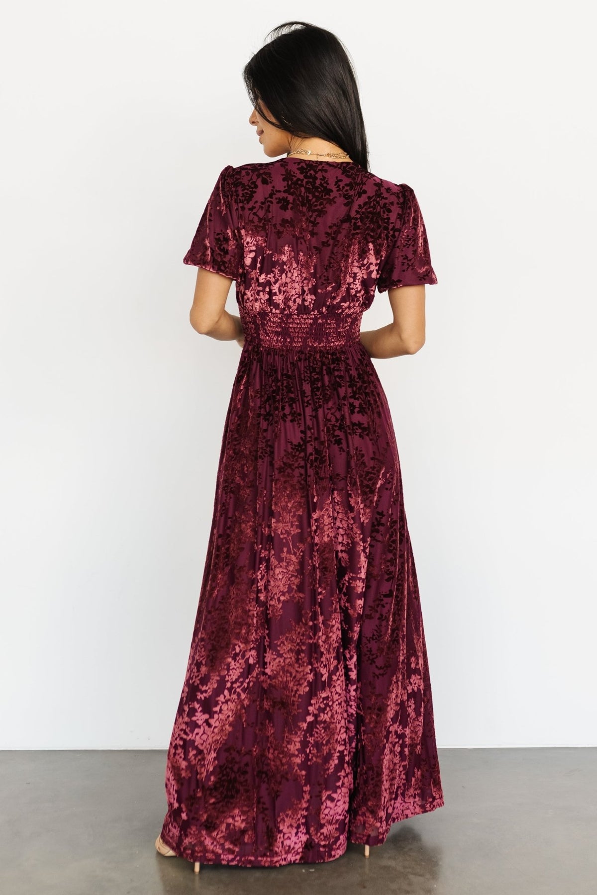Model wearing the Mulberry velvet maxi dress walking to show skirt movement, full lining and floor-skimming length.