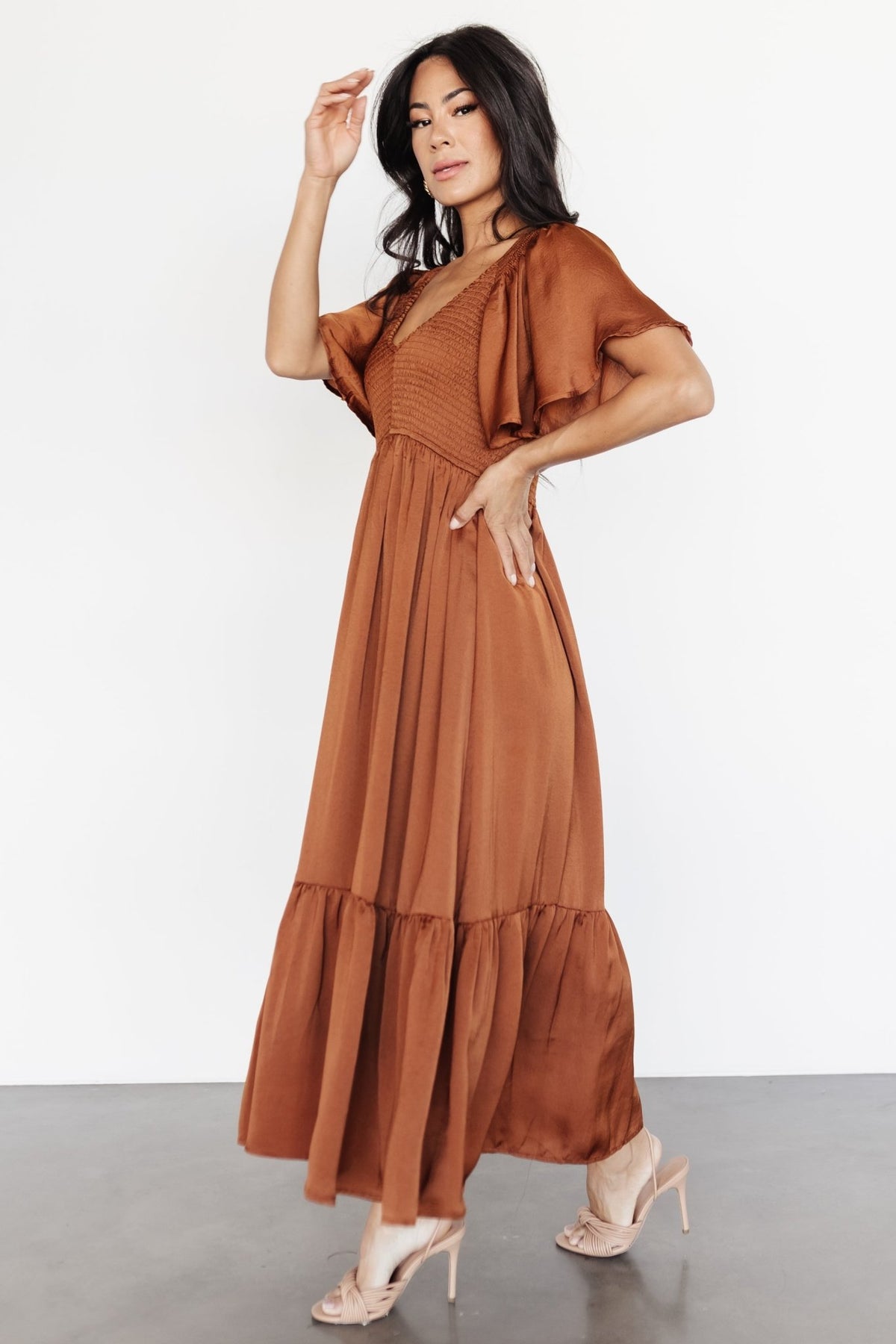 Side profile of the dress on model showing gentle A-line skirt, lined construction, and ruffle hem shape.