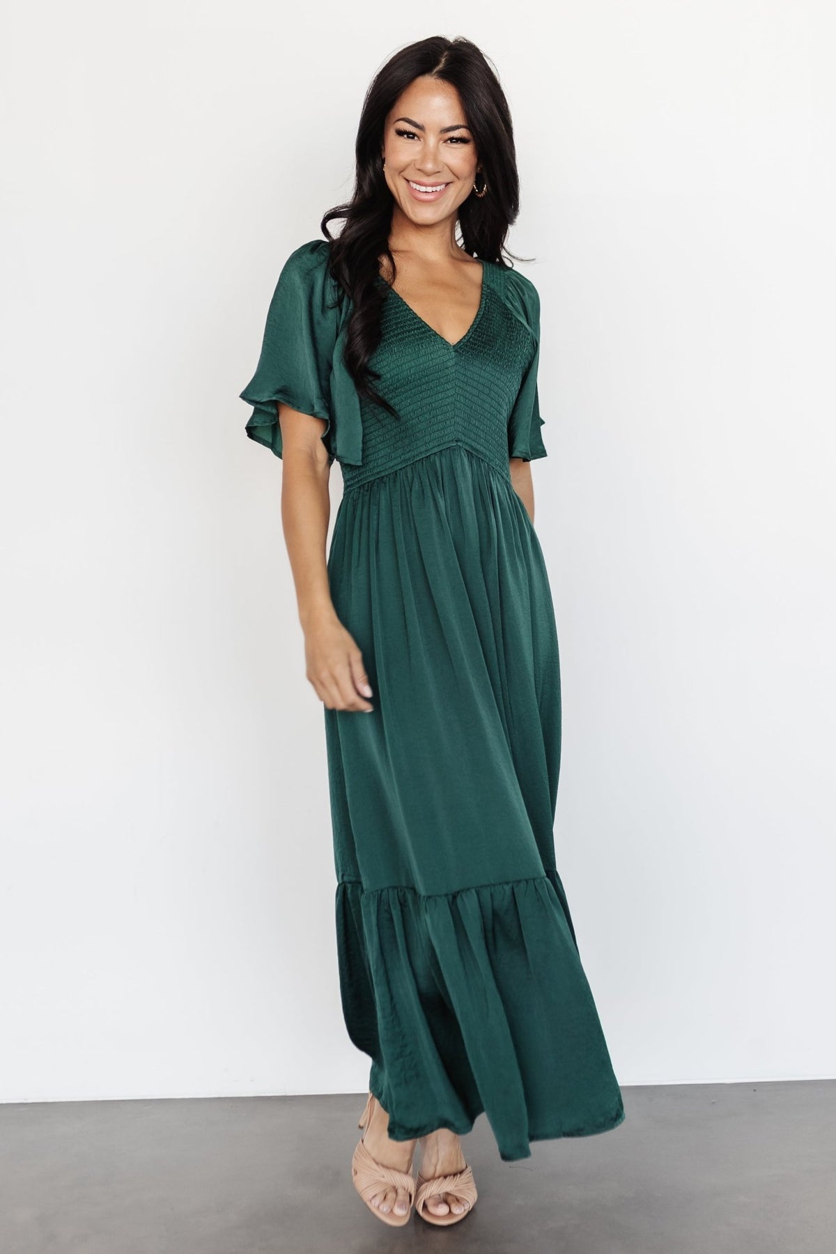 Close-up of smocked bodice and rounded V neckline on Lovell Smocked Midi Dress in emerald, satin-like texture visible.