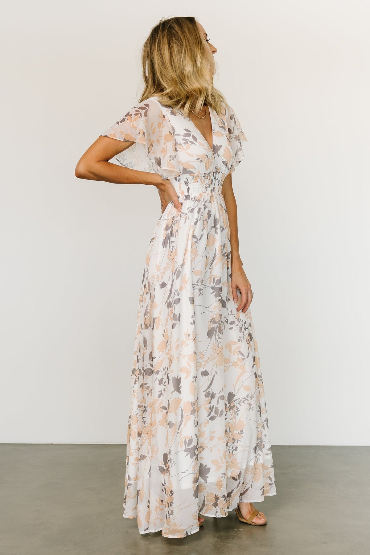 Back and side view of off-white Lynlee metallic maxi dress highlighting flowing skirt, full lining through body, and elegant movement.