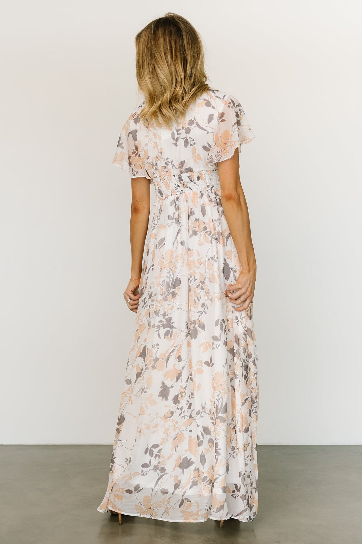 Full-length image of off-white printed chiffon maxi dress with metallic accents, ideal for events and maternity-friendly styling options.