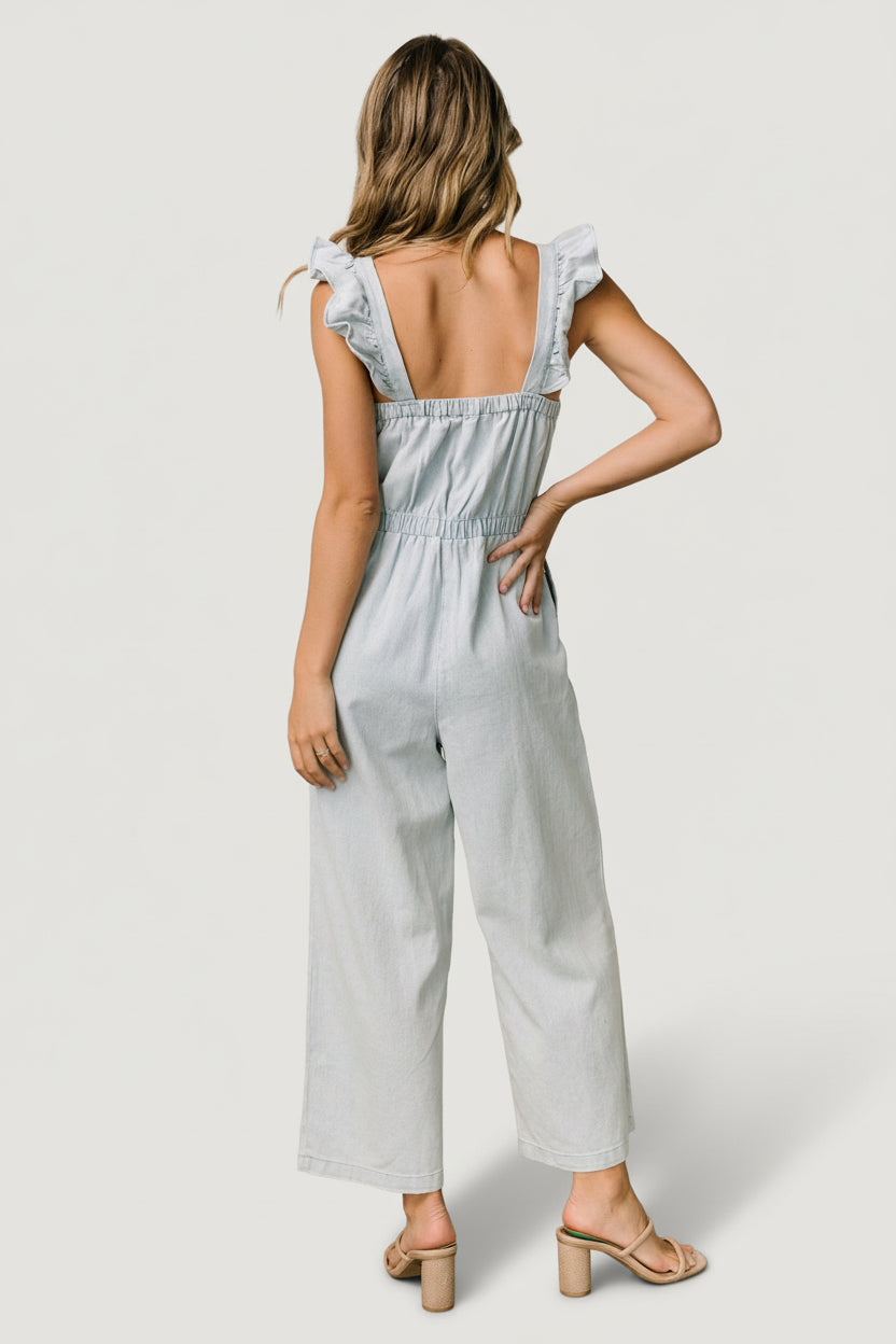 Back view of the denim jumpsuit showing elastic back neckline and relaxed waist shaping for flexible fit.