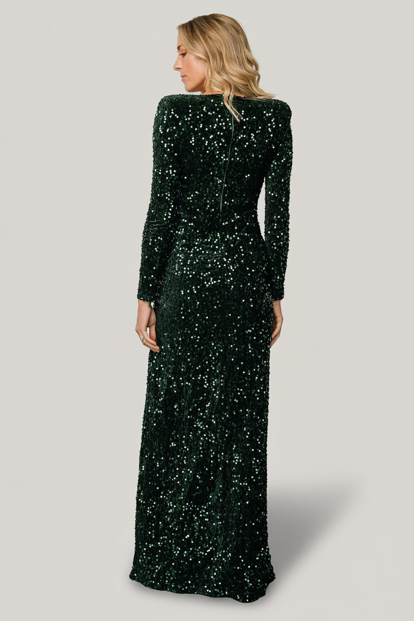 Three-quarter view of emerald sequin velvet gown highlighting shoulder padding, side ruching and the hidden back zipper detail.