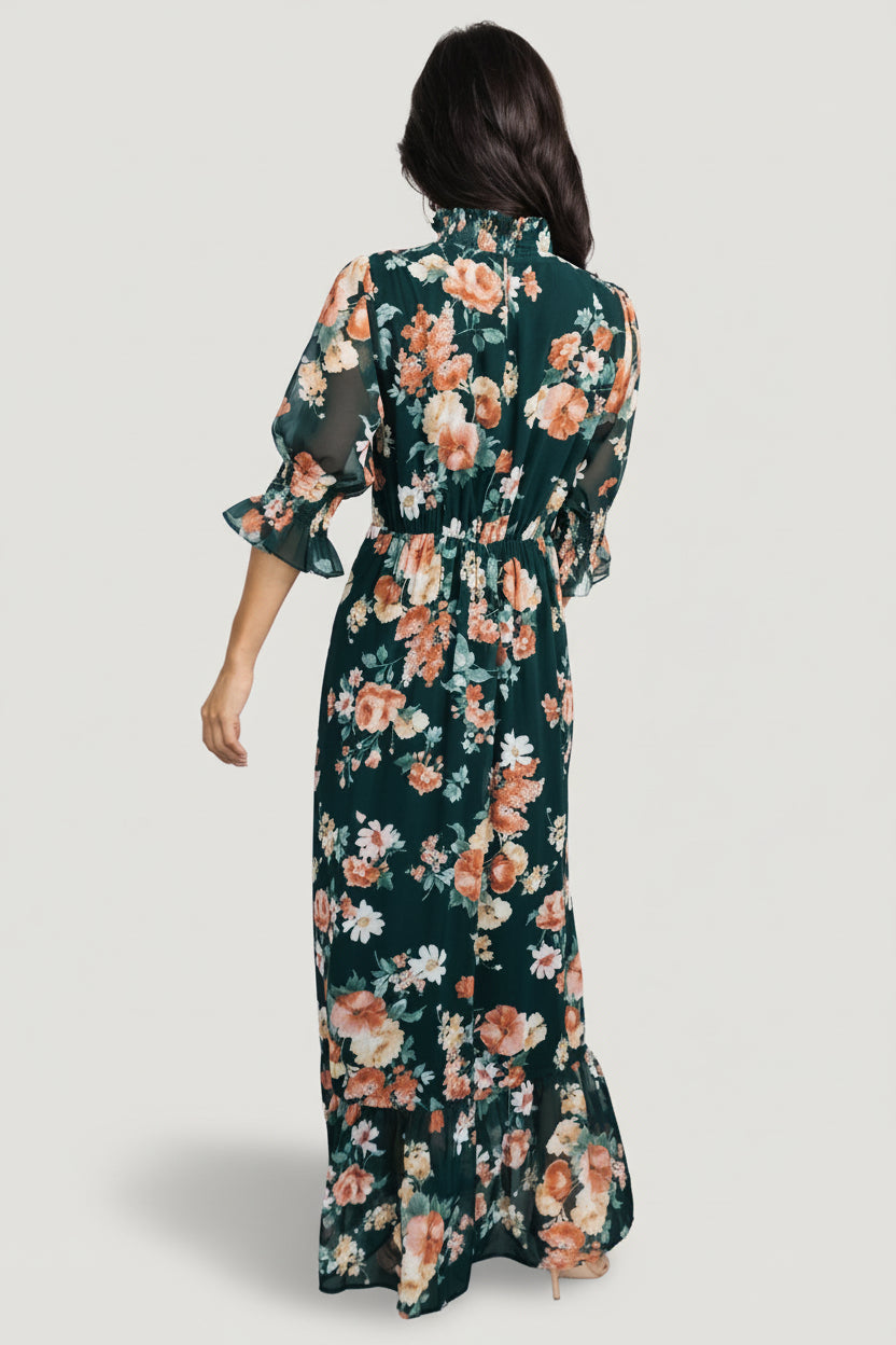 Detail close-up of smocked mock neckline and smocked ruffle cuff on the dark green floral chiffon Marie maxi dress.