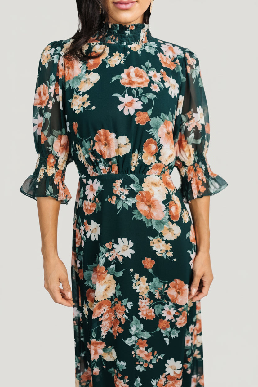 Side view of Marie mock neck maxi dress showing flowing single-tiered skirt, pleated front waist, and elasticized back for comfortable fit.