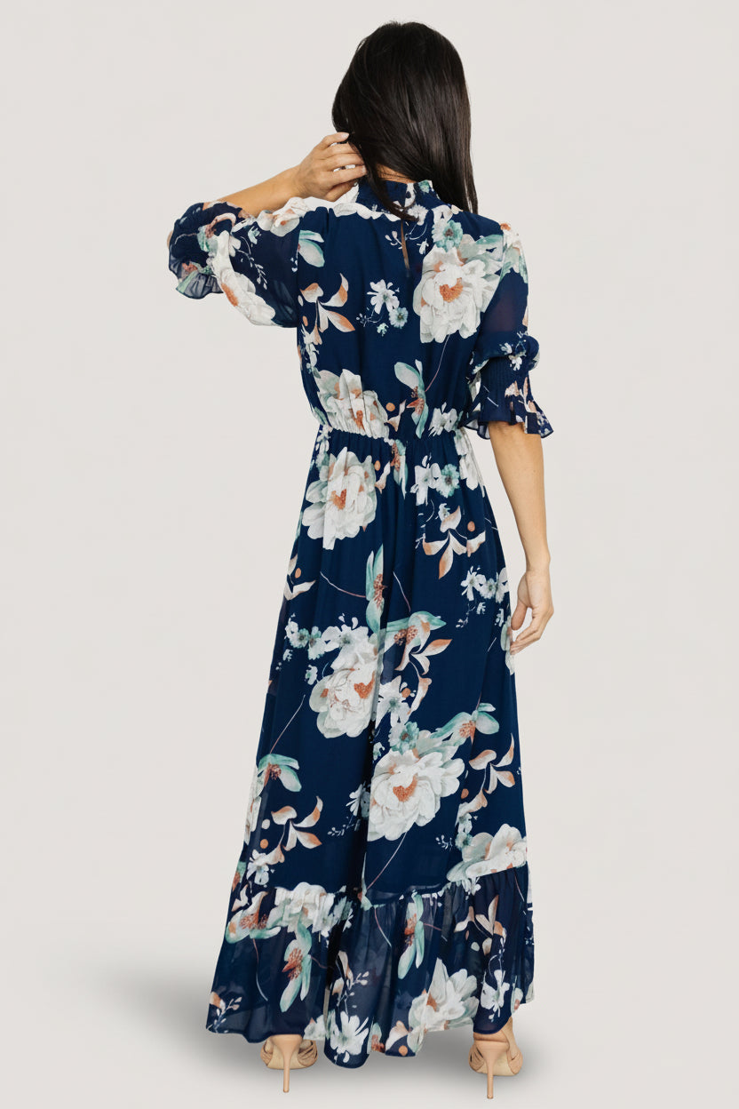 Back view highlighting the keyhole and double button closure at the smocked high neck and elastic back waist detail.