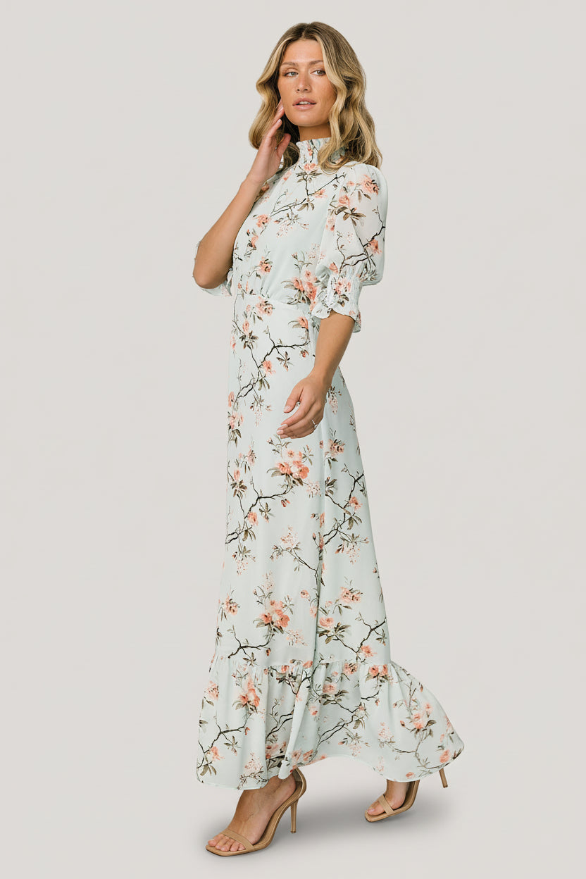 Side view of Marie Mock Neck Maxi Dress in sage floral, highlighting elastic back waist, graceful single-tier hem and light chiffon drape.