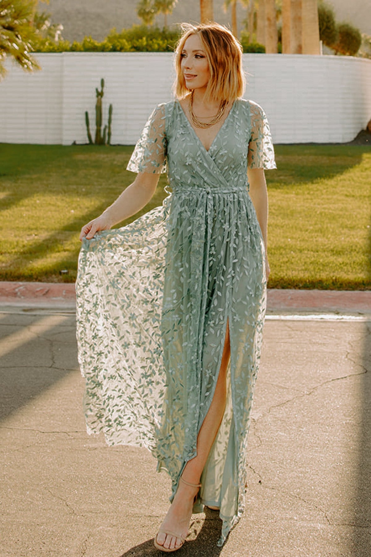 Full-length shot of eucalyptus gown showing structured organza texture, short unlined flutter sleeves, inverted lining seam, and ankle-grazing hem with raw cut finish.