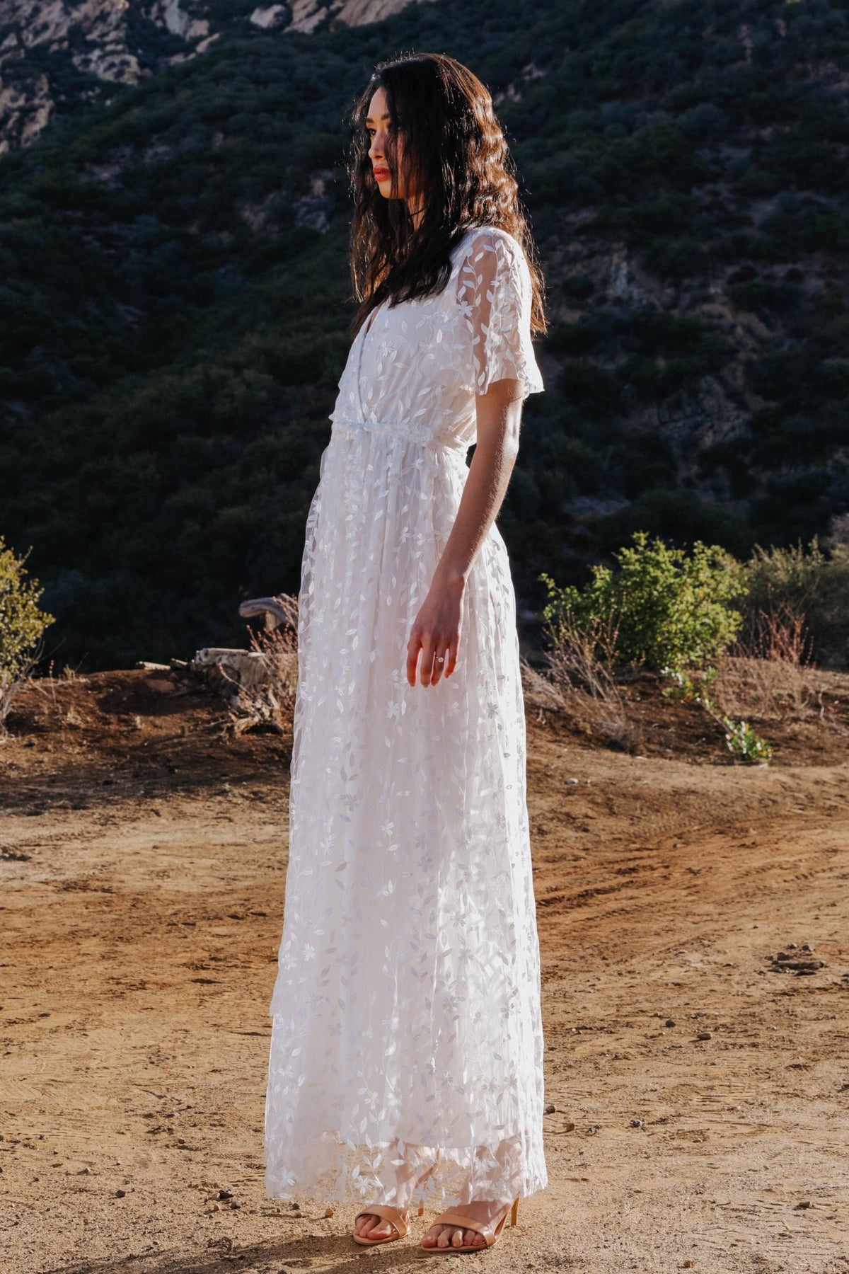 Plus-size model wearing the Marseille vine-embossed organza maxi dress in white, illustrating inclusive sizing and relaxed but defined waistline.