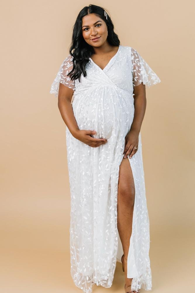 Side view of Marseille vine-embossed maxi dress in white, showing the left-leg slit, raw cut hem, and the way the fabric moves.