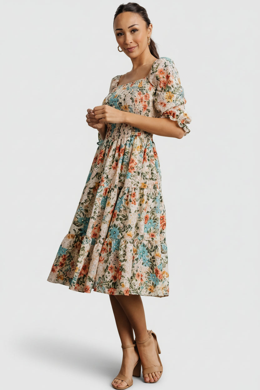 Movement shot capturing the tiered hem and lightweight drape of the midi dress in a bright multi floral motif