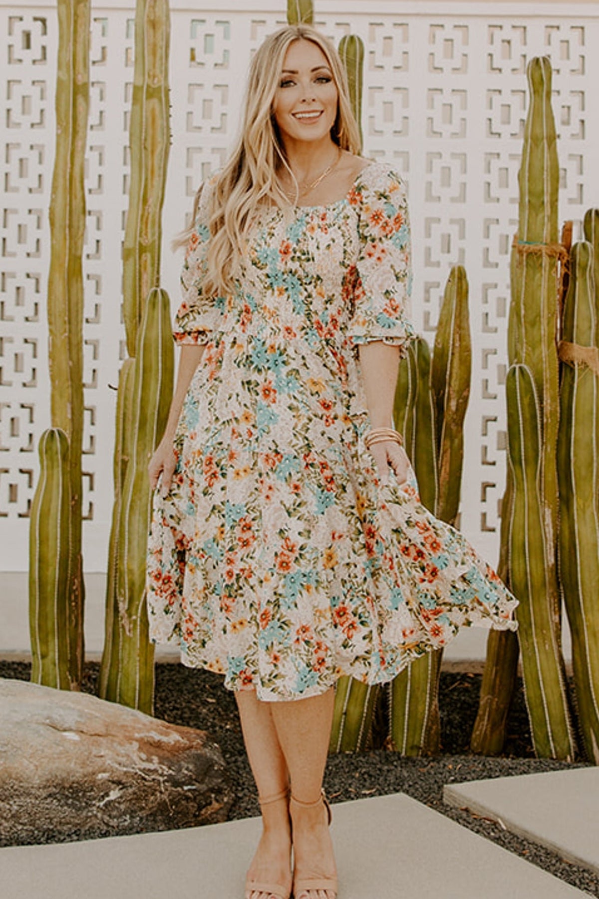 Back view showing tiered skirt and gathered waist of the multi floral smocked midi dress, visible sleeve ruffle and hem movement