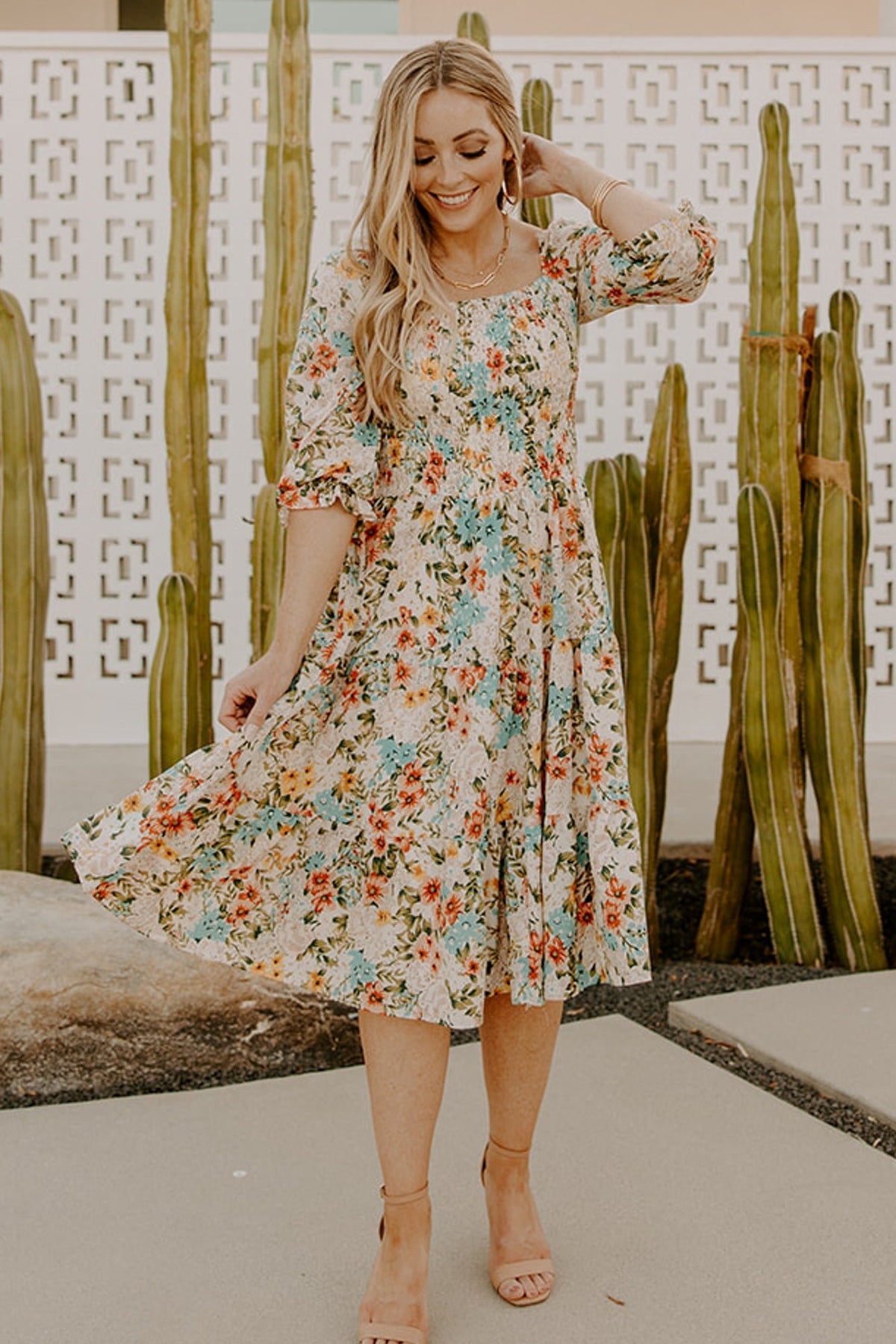 Close-up of fully smocked bodice and square neckline detail with elastic at the shoulders, floral print visible