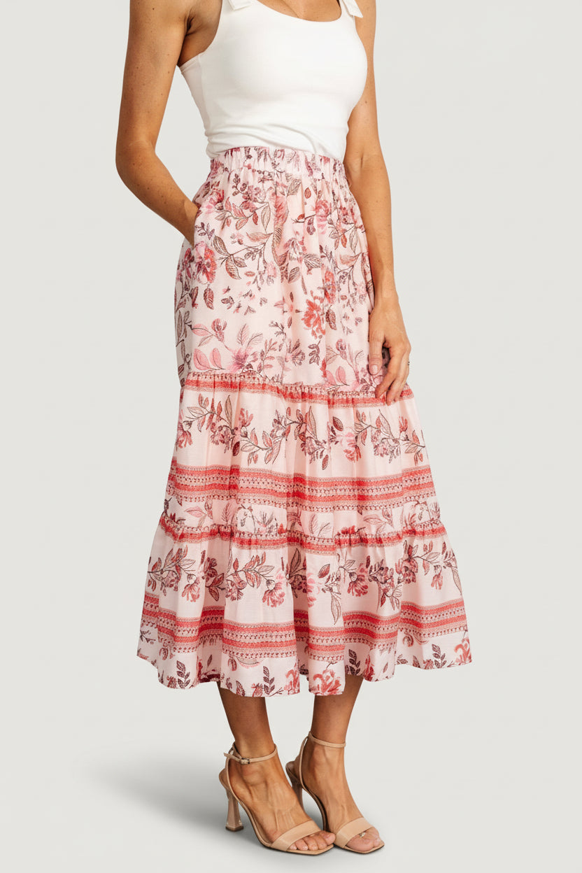 Side view of model wearing Meg tiered skirt, displaying hidden side pocket opening and the smocked waistband that stretches to fit the waist.