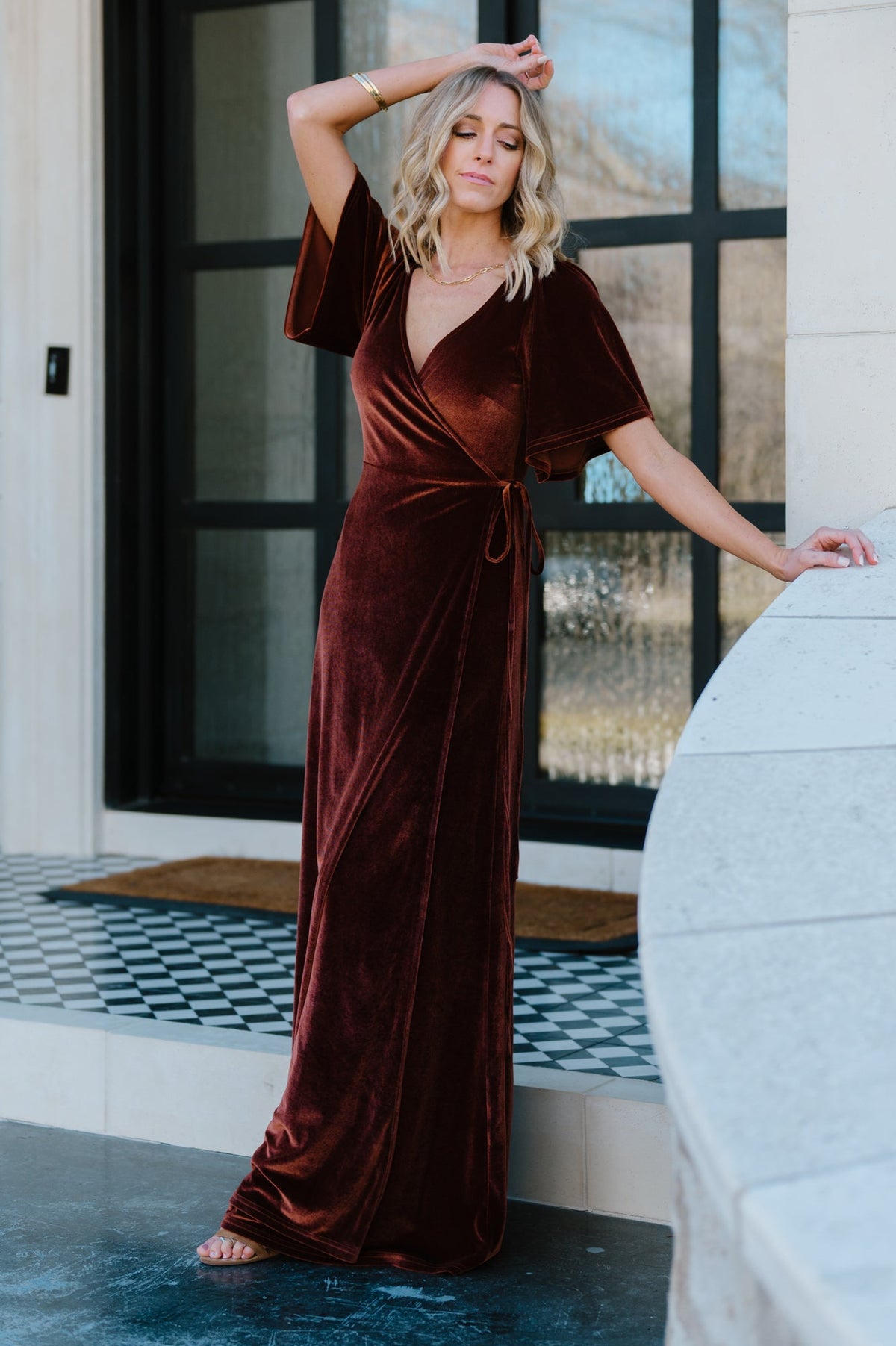 Close-up of sleeve showing subtle bell shape and seam detail on bronze velvet wrap dress, demonstrating feminine sleeve proportion.