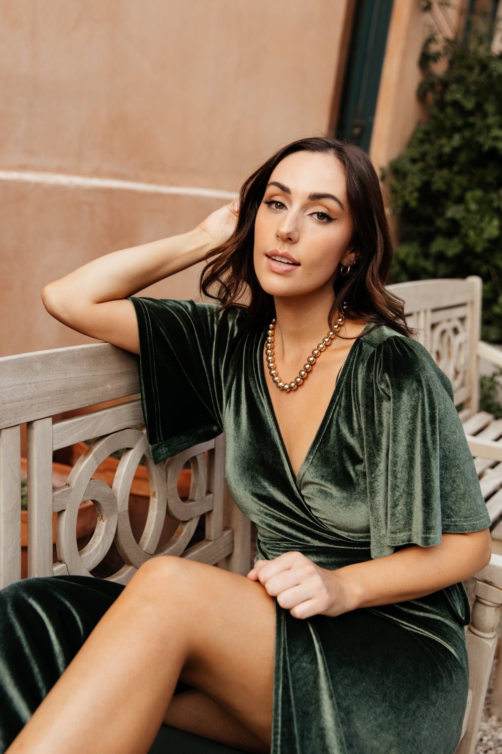 Model walking in the deep-green velvet wrap maxi, demonstrating the flowing tulip hem and graceful movement of the Meghan dress.