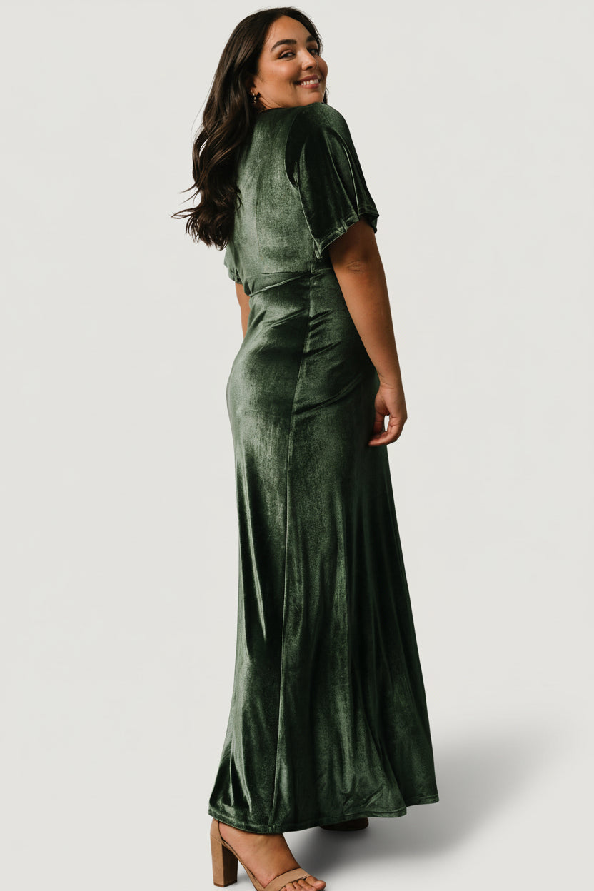Detail view of the mid-length bell sleeve and velvet texture on the deep-green Meghan wrap maxi dress, highlighting fabric and finish.