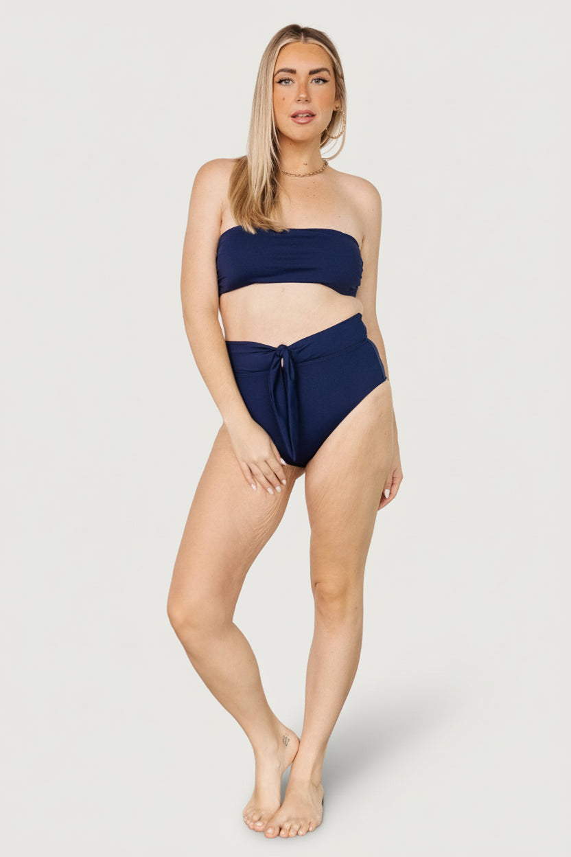 Back detail of the Milos tie-back bikini top in navy, focused on the tie knot, strap placement, and reinforced stitching for secure wear.