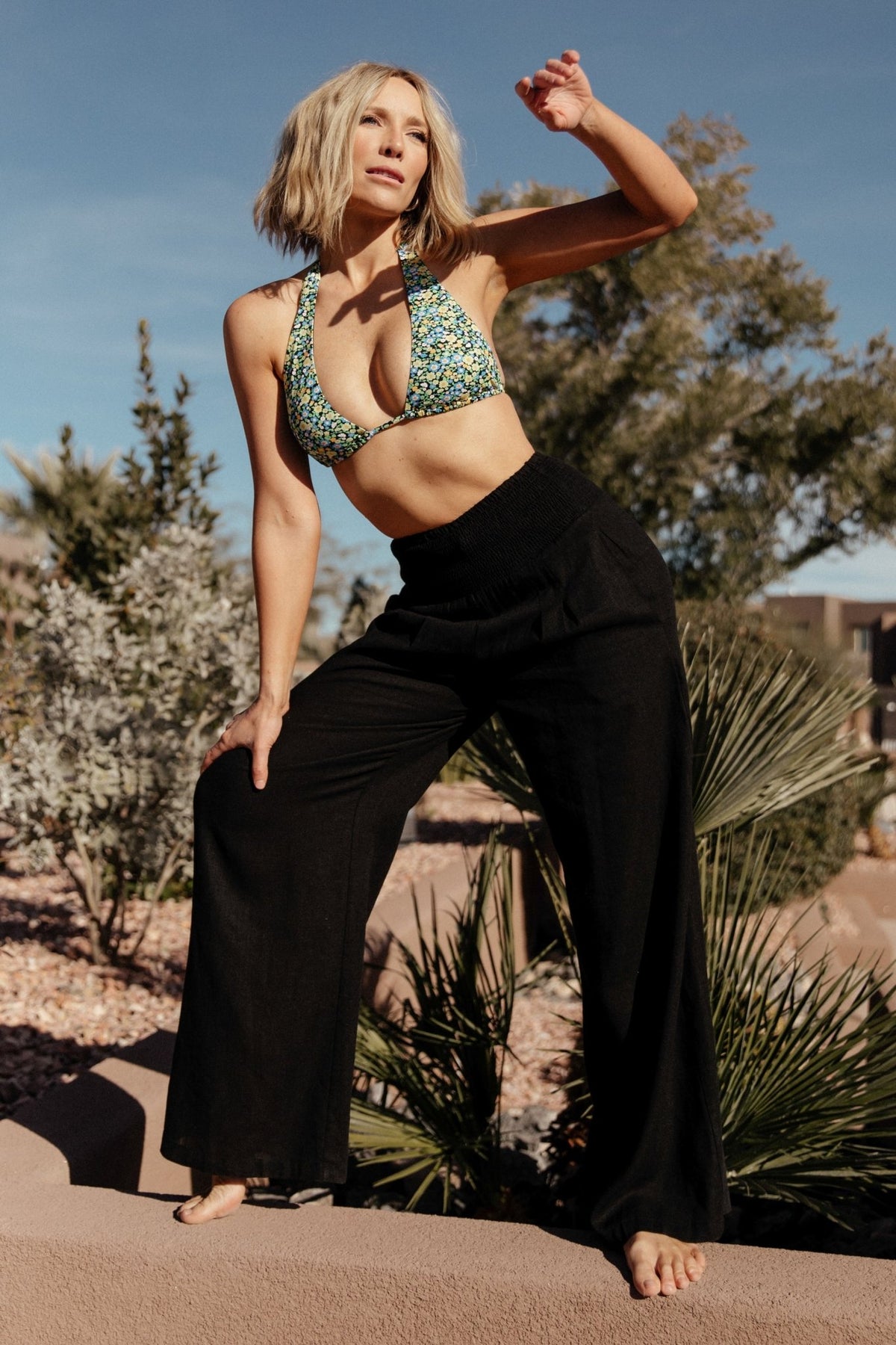 Studio product image of Parvati black wide-leg pants with smocked waistband and visible side pocket detail.