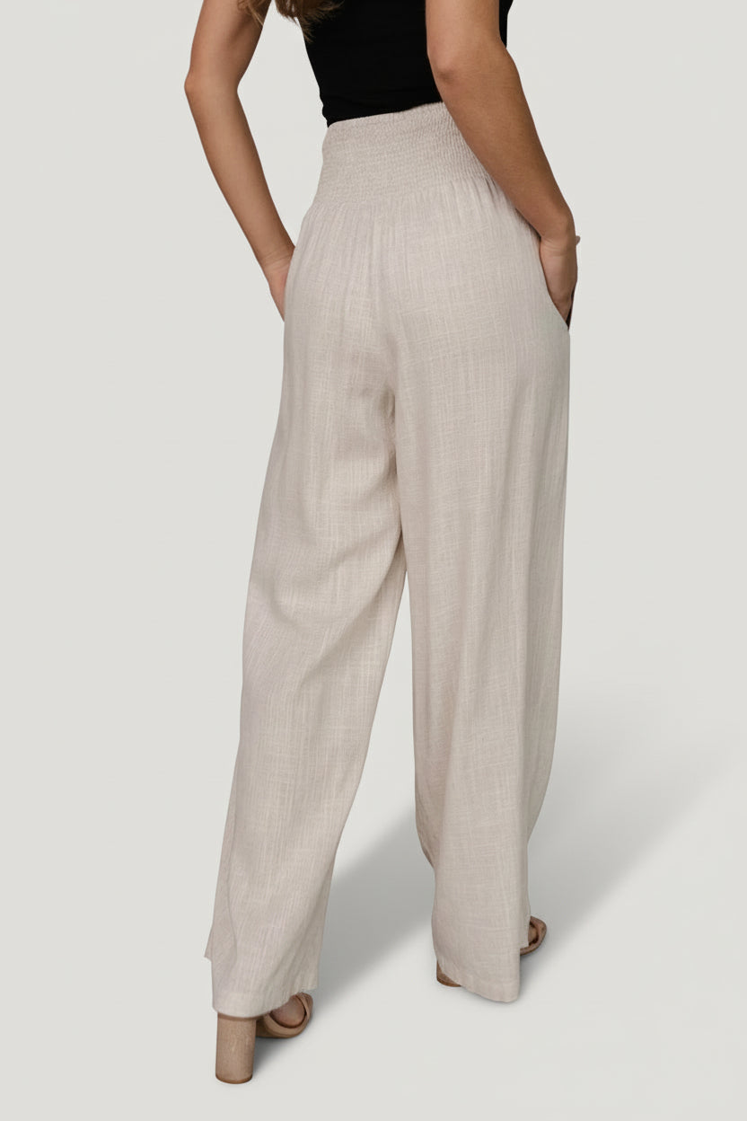 Side view of model walking in Parvati wide-leg pants, showing movement, side pocket, and relaxed silhouette.
