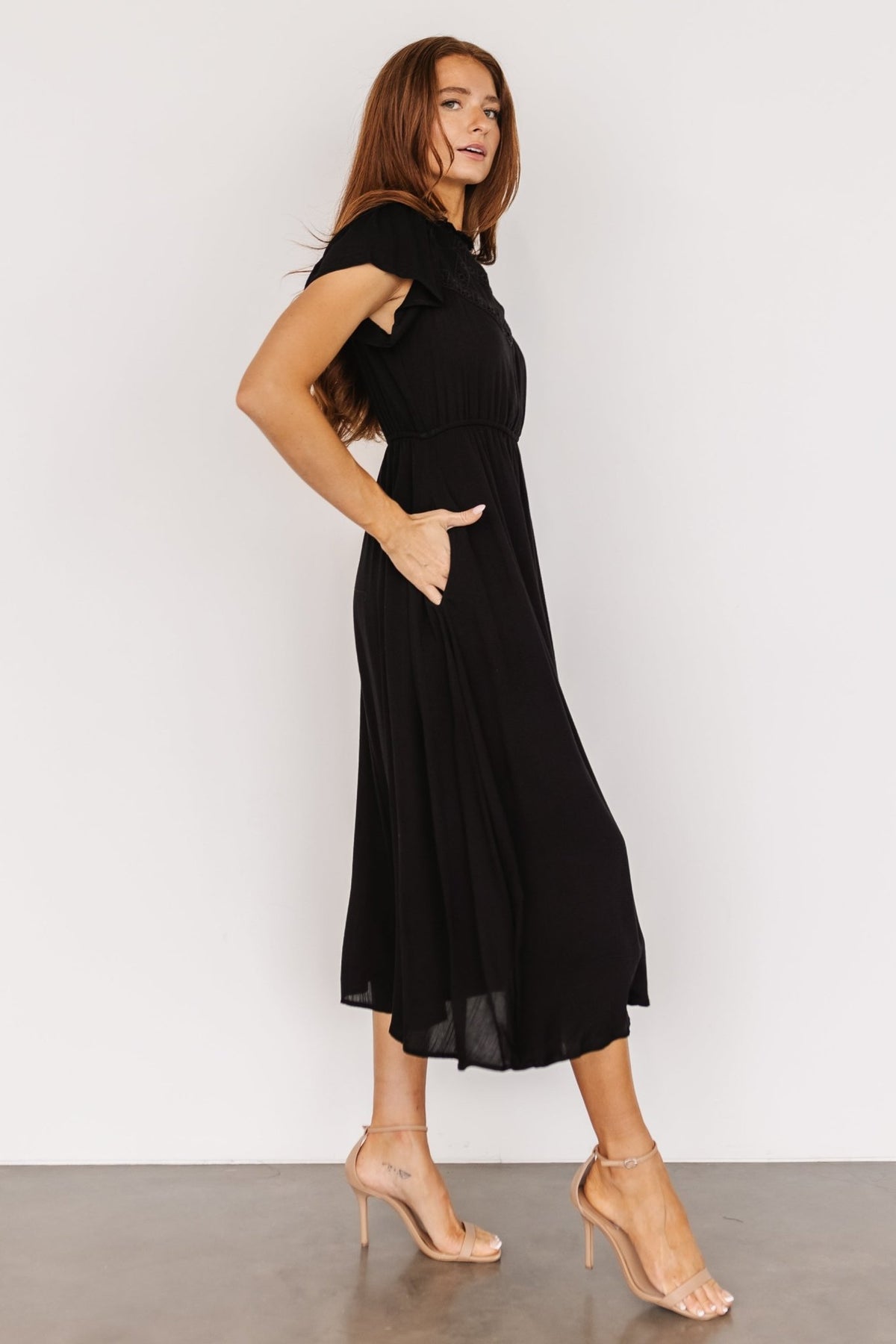 Back detail of the black Prestyn midi dress displaying the keyhole back with button closure and the fully lined skirt.