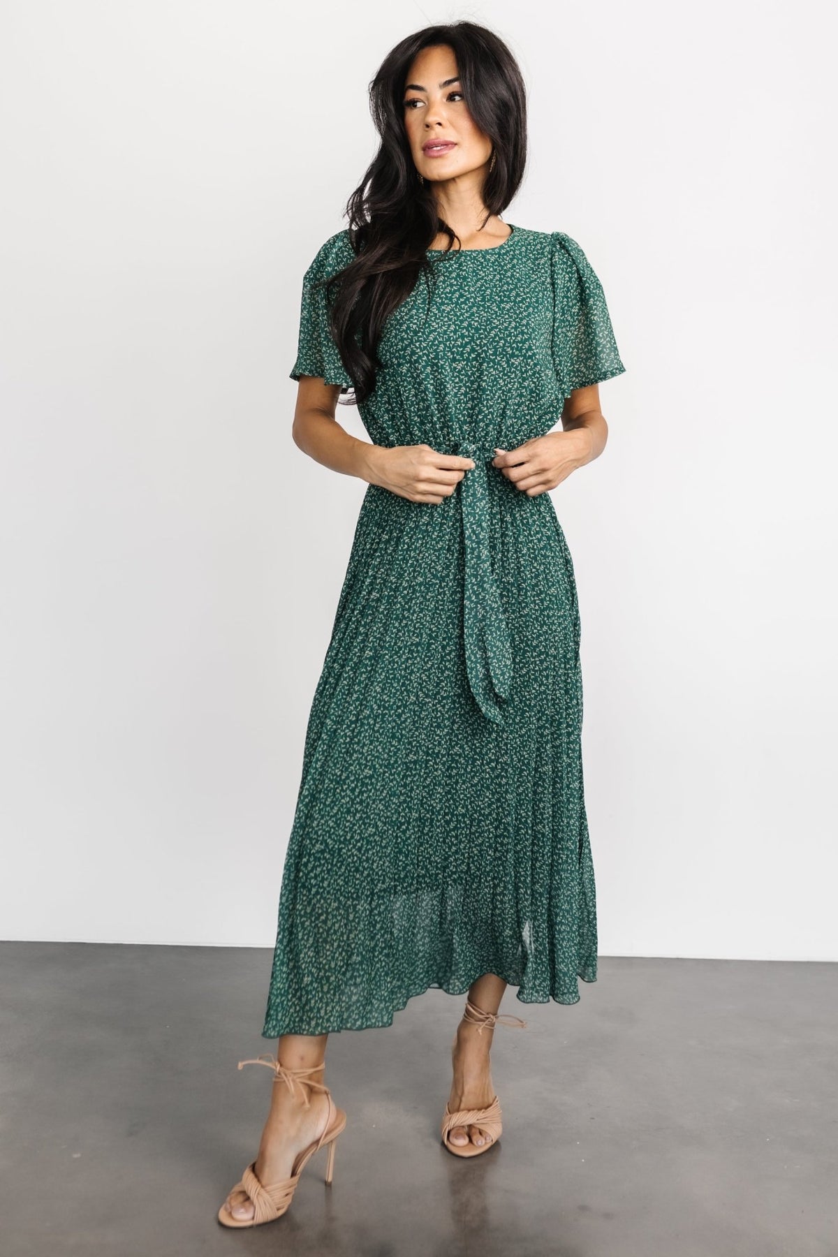 Green floral chiffon pleated midi dress on model, short sleeves, round neckline, elastic gathered waist with removable tie.