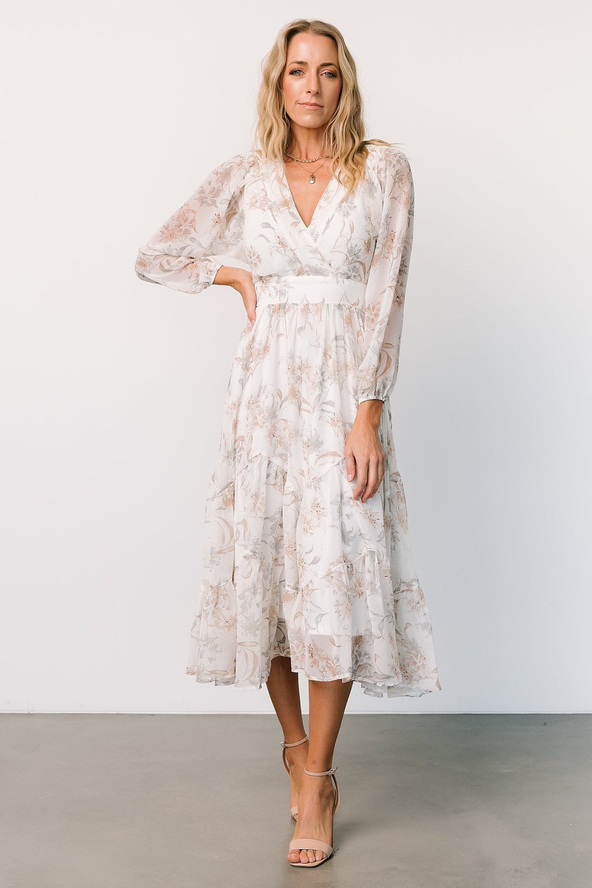 Three-quarter view of the Raven midi dress in off-white floral, highlighting long sheer sleeves and the flowing chiffon fabric movement.