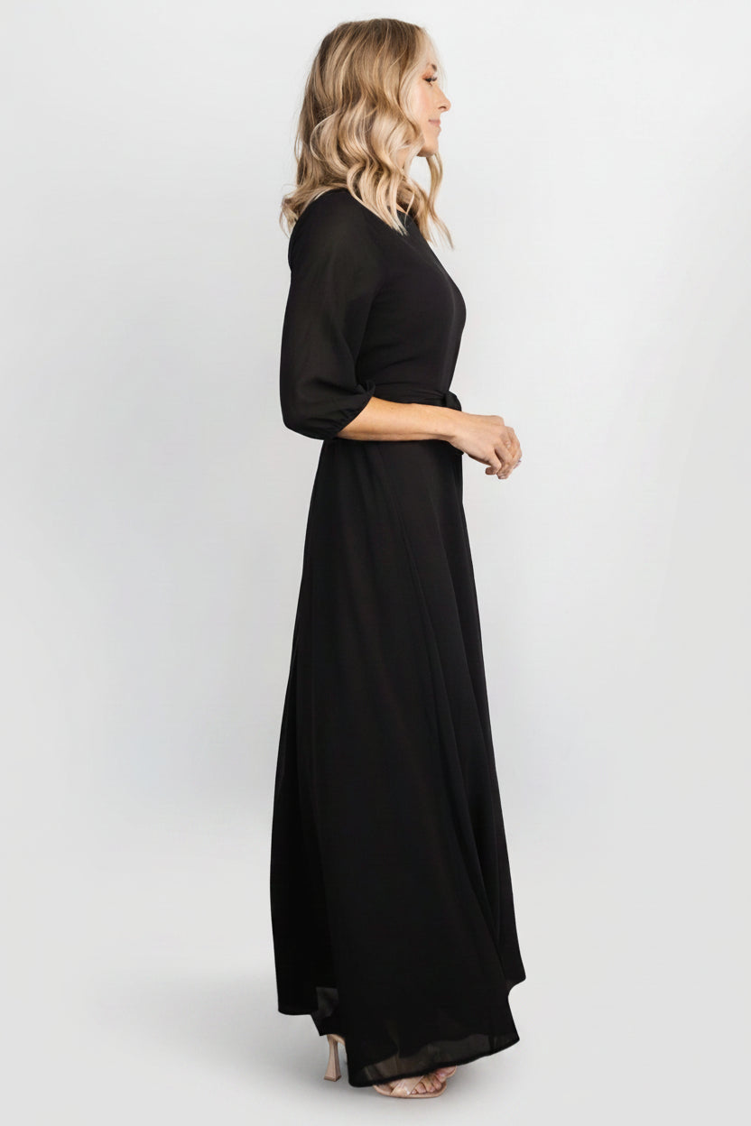 Detail shot of Rebecca Maxi Dress in black focusing on the removable belt tie at the natural waist and soft polyester fabric texture.