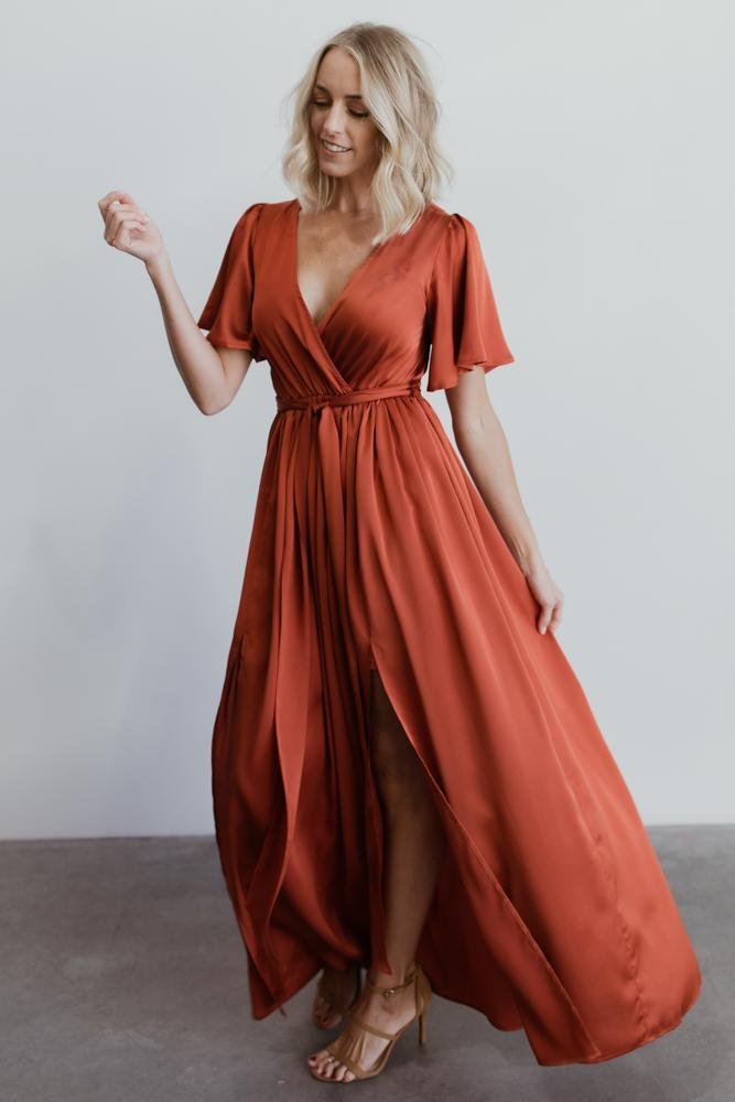 Image focusing on the flutter sleeve and shoulder seam of the rust satin maxi to show sleeve length and fabric texture.