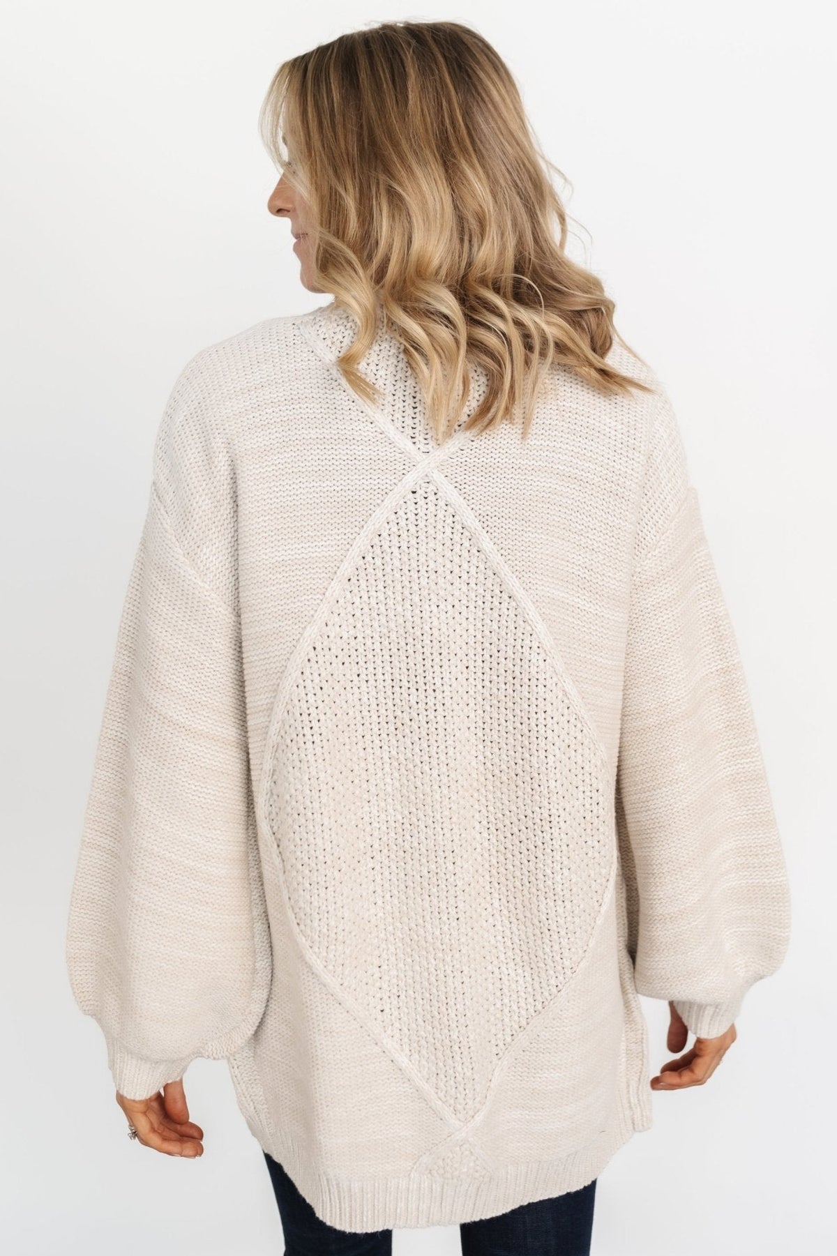 Three-quarter view of Spencer chunky knit cardigan in oatmeal demonstrating oversized fit and clean open-front line.