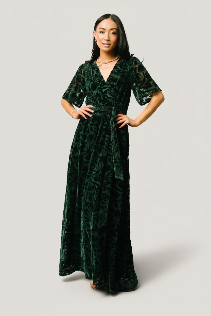 Close-up of the burnout mesh floral velvet fabric on the dark green Uma dress highlighting texture, floral pattern, and velvet sheen.